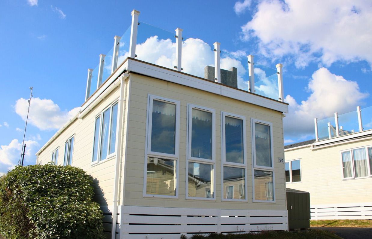 External of a caravan on pitch with skydeck and outdoor furniture 