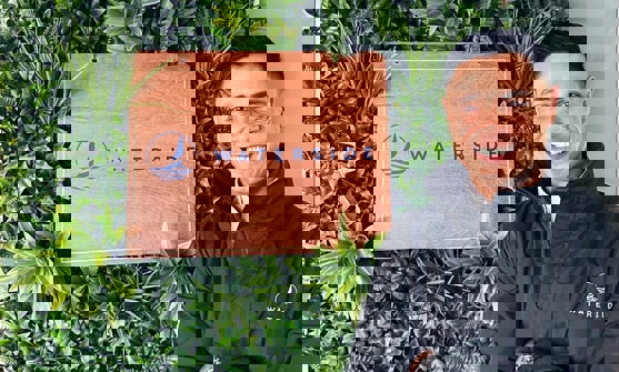 A smiling man stood beside a Waterside sign