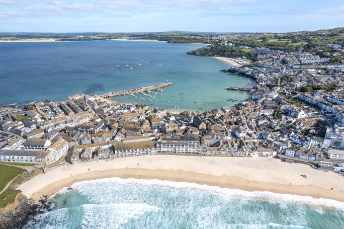 A sandy stretch of beach alongside a town