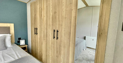 Internal of a caravan master bedroom with storage