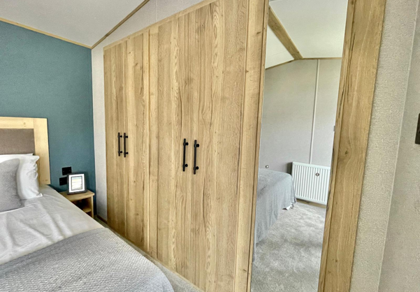 Internal of a caravan master bedroom with storage