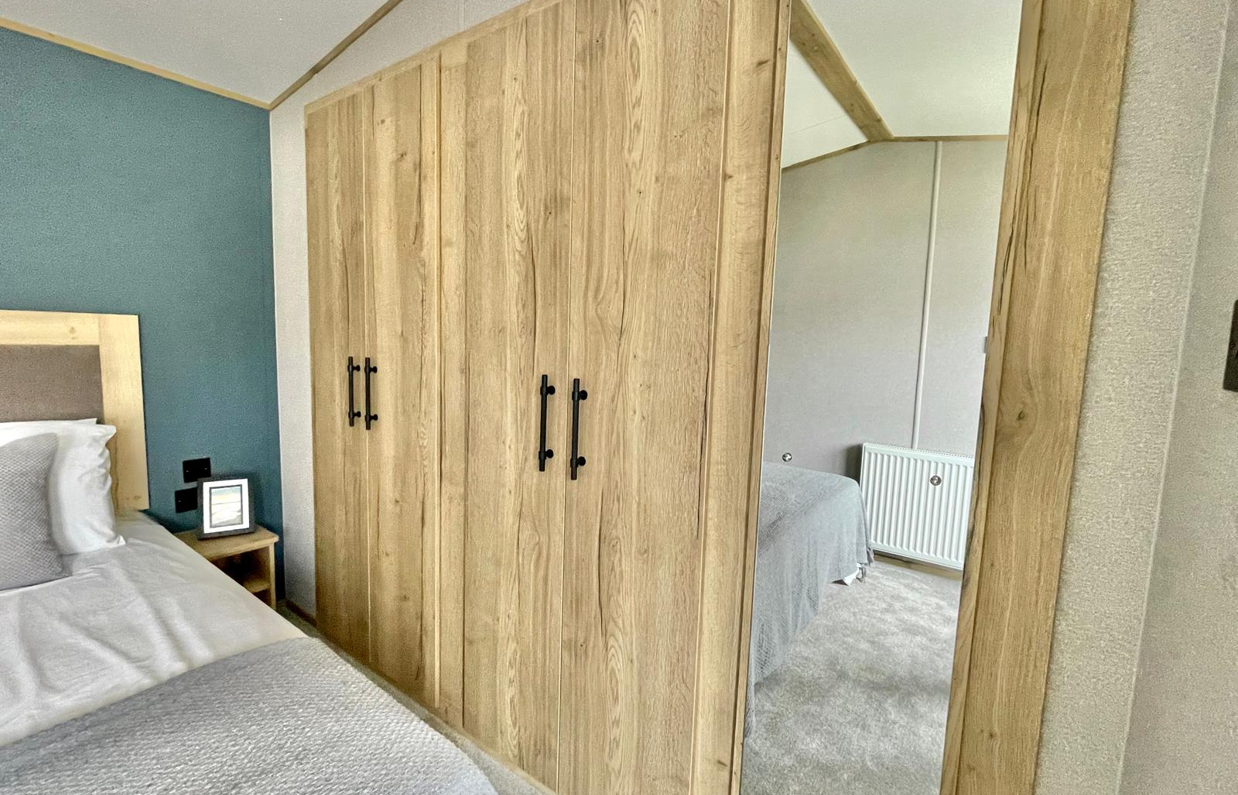 Internal of a caravan master bedroom with storage