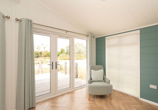 Internal of a luxury lodge open plan living space with french doors out to decking