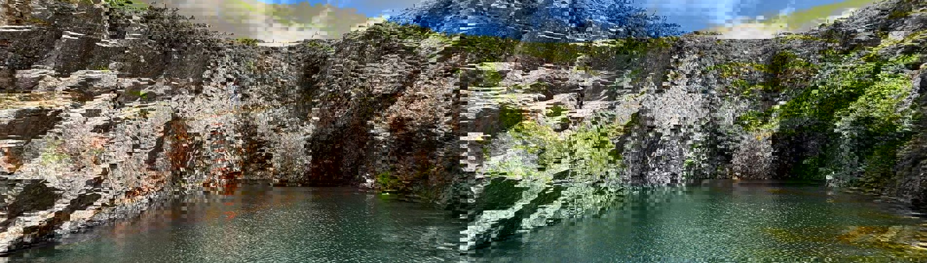 A quarry with a body of water in the centre 