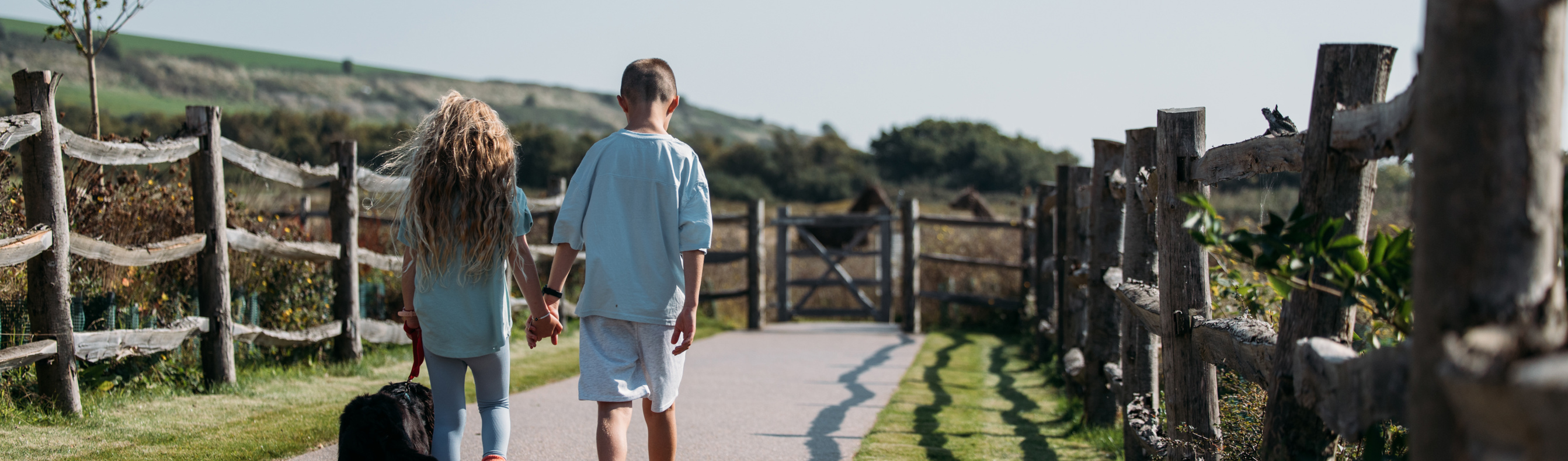 Children walking their dog through countryside on-park