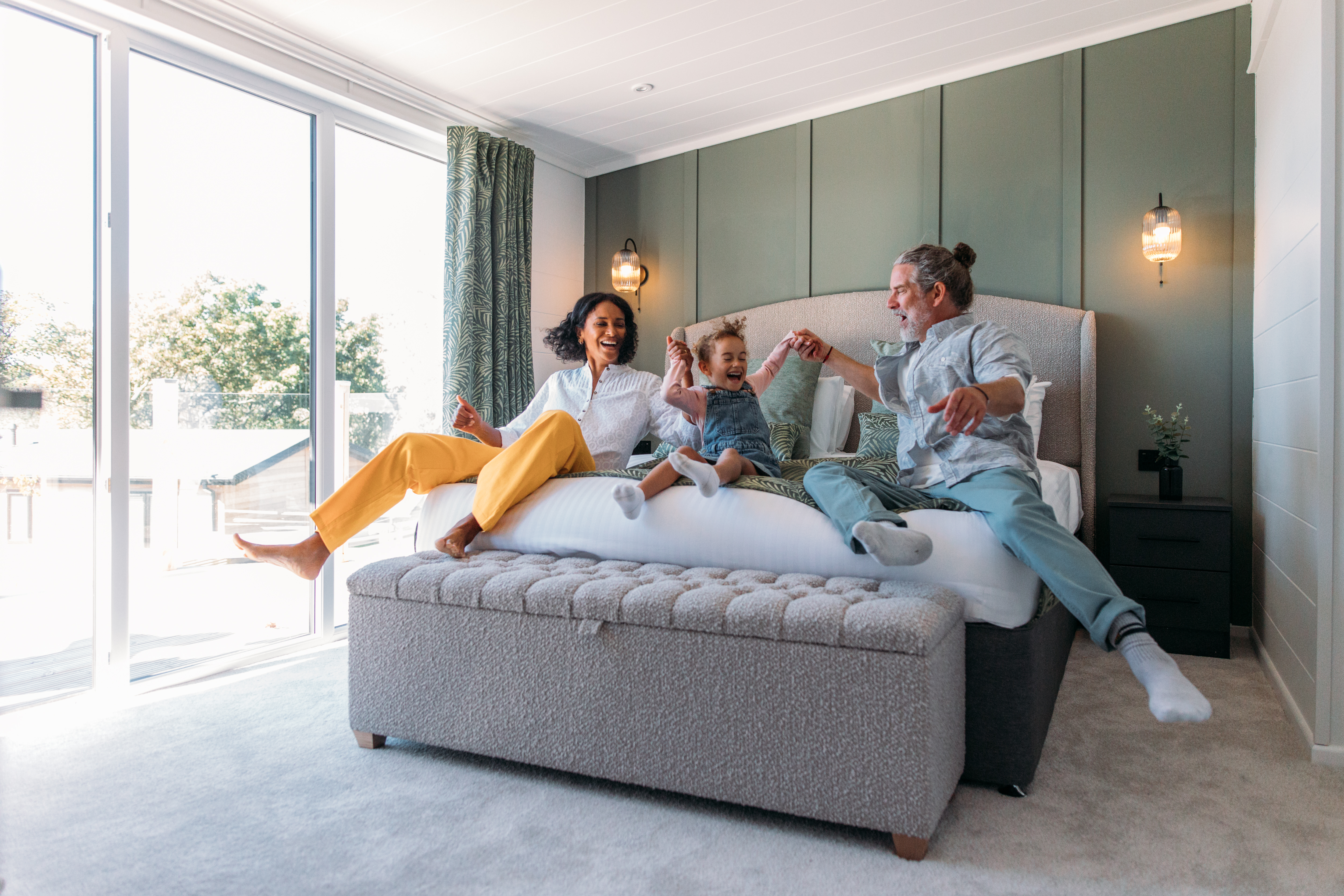 Family excitedly jumping onto the parent's bed together
