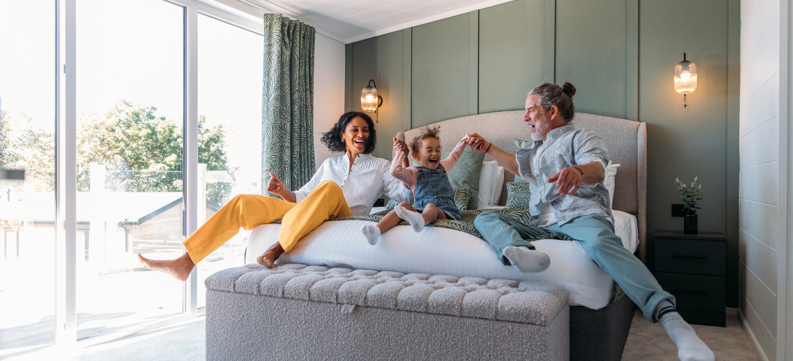 Family excitedly jumping onto the parent's bed together