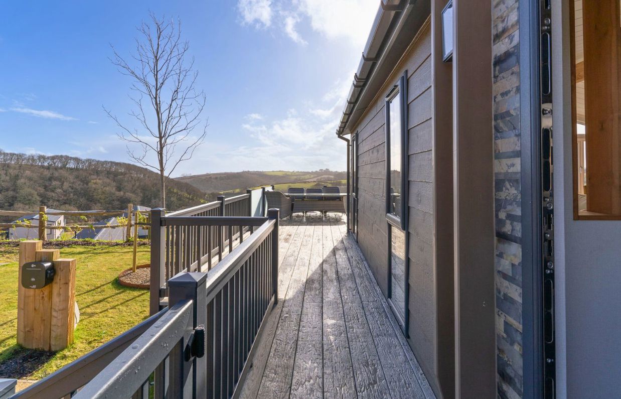 External of a luxury lodge on pitch with decking and countryside views