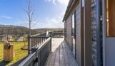 External of a luxury lodge on pitch with decking and countryside views