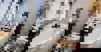 Modern bathroom with bath tub, marble splashbacks and black accessories