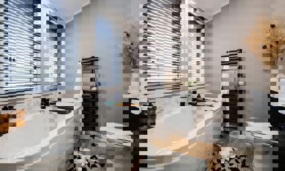 Modern bathroom with bath tub, marble splashbacks and black accessories