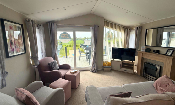 Internal of a caravan lounge looking out to decking