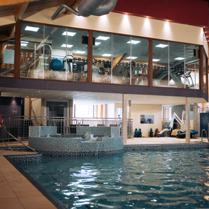 A heated indoor pool with jacuzzi area and gym