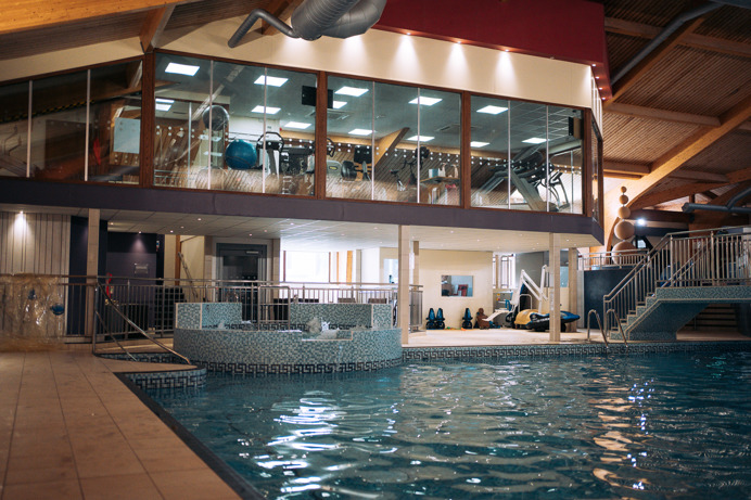 A heated indoor pool with jacuzzi area and gym