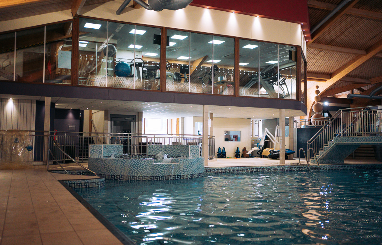 A heated indoor pool with jacuzzi area and gym