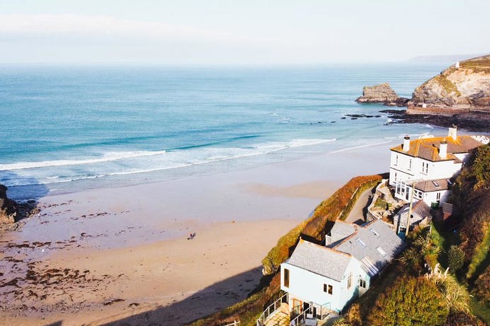 A sandy quiet stretch of beach with a few surrounding houses