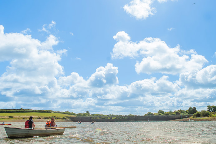 Tamar Lake with rowers in rowing boats on a sunny day