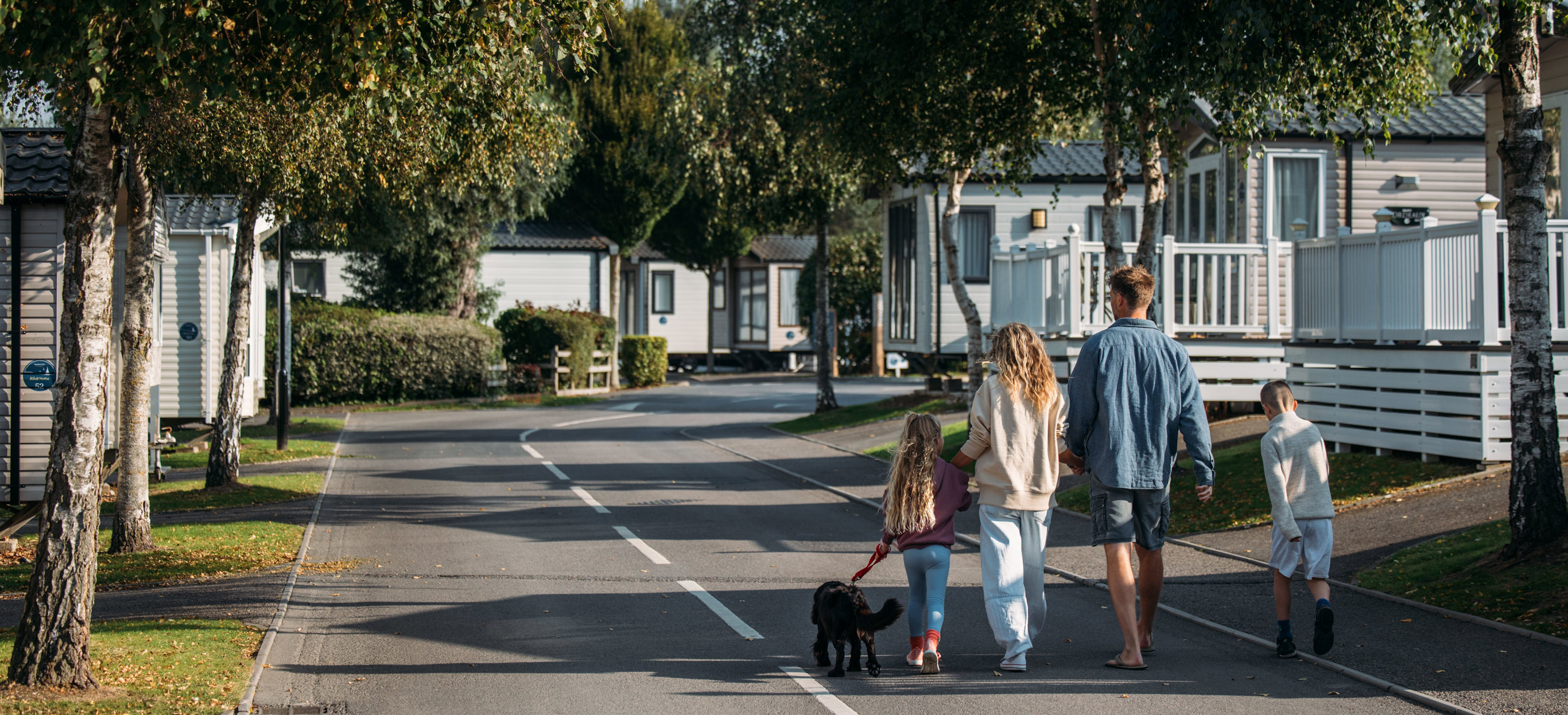 Family and dog walking down lane at Bowleaze Cove Holiday Park