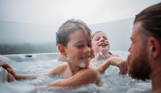 Two young boys and a man playing in a hot tub at Tregoad Holiday Park on a cloudy day