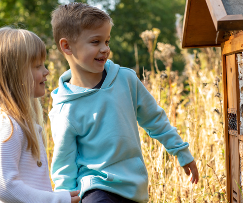 A young boy and girl smiling looking at nature