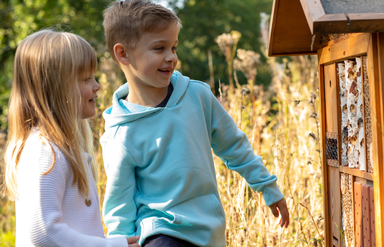 A young boy and girl smiling looking at nature