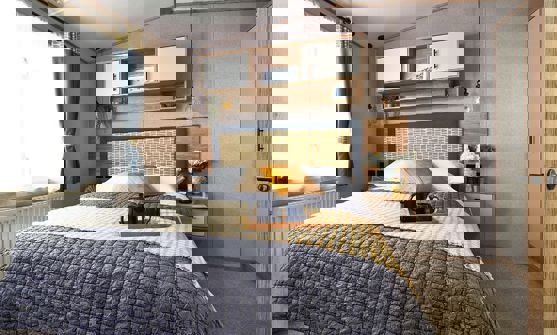 Comfy king size bed with separate wardrobe and shelving unit above the bed