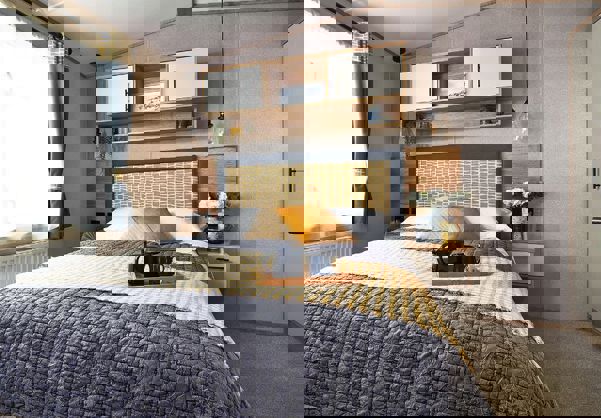 Comfy king size bed with separate wardrobe and shelving unit above the bed