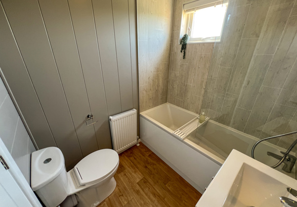 Internal of a luxury lodge bathroom with shower over bath toilet and sink
