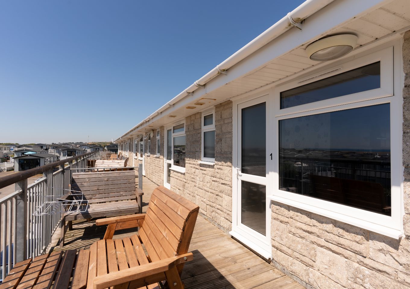 Front door of Chesil Beach apartments with outdoor furniture on the balcony