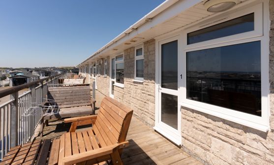 Front door of Chesil Beach apartments with outdoor furniture on the balcony
