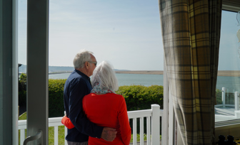 Chesil Beach Owners cuddling on deck looking over lagoon