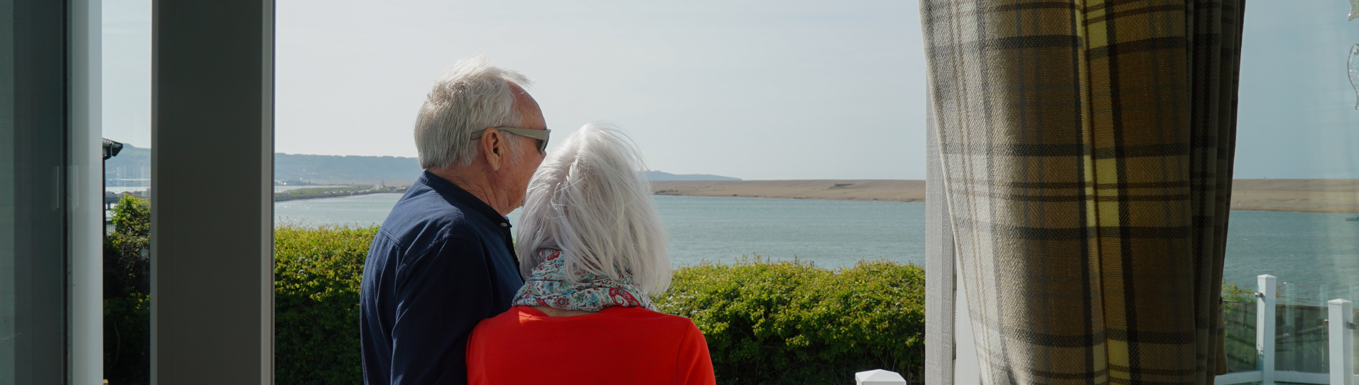 Chesil Beach Owners cuddling on deck looking over lagoon