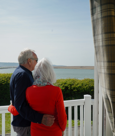 Chesil Beach Owners cuddling on deck looking over lagoon