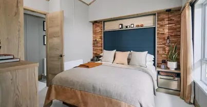 Master bedroom with natural stone colour them and faux brick wall with built-in storage