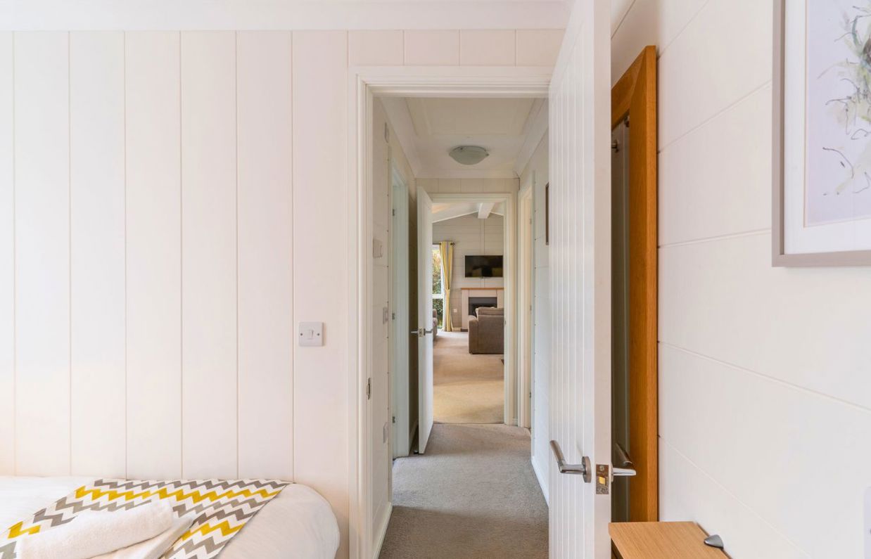 Internal of a lodge twin bedroom looking down towards the hallway and open plan living space