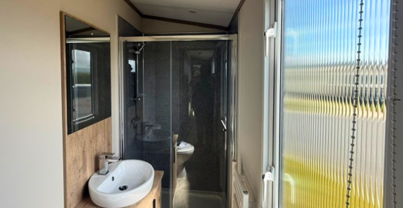 Internal of a caravan bathroom with shower, sink and toilet