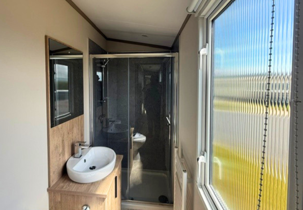 Internal of a caravan bathroom with shower, sink and toilet