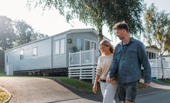 Couple holding hands and walking through a holiday park