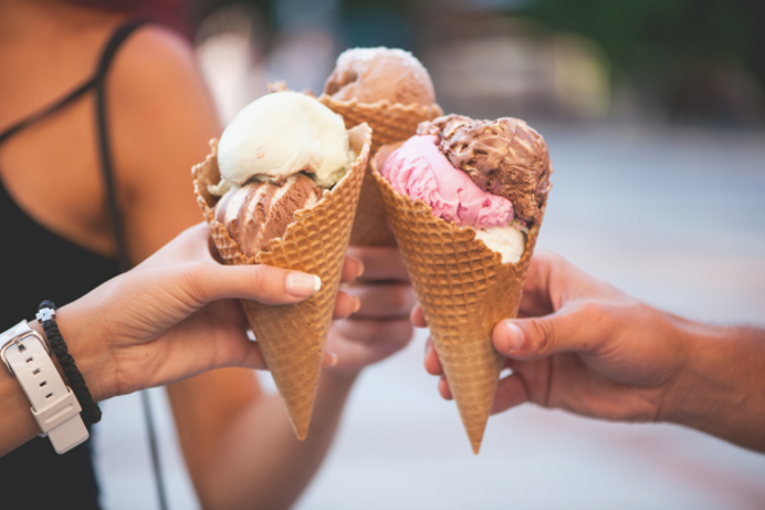 Three scoops of chocolate, strawberry and vanilla ice cream in three waffle cones