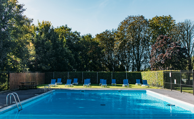 An outdoor pool with a sun terrace and sun loungers on a sunny day