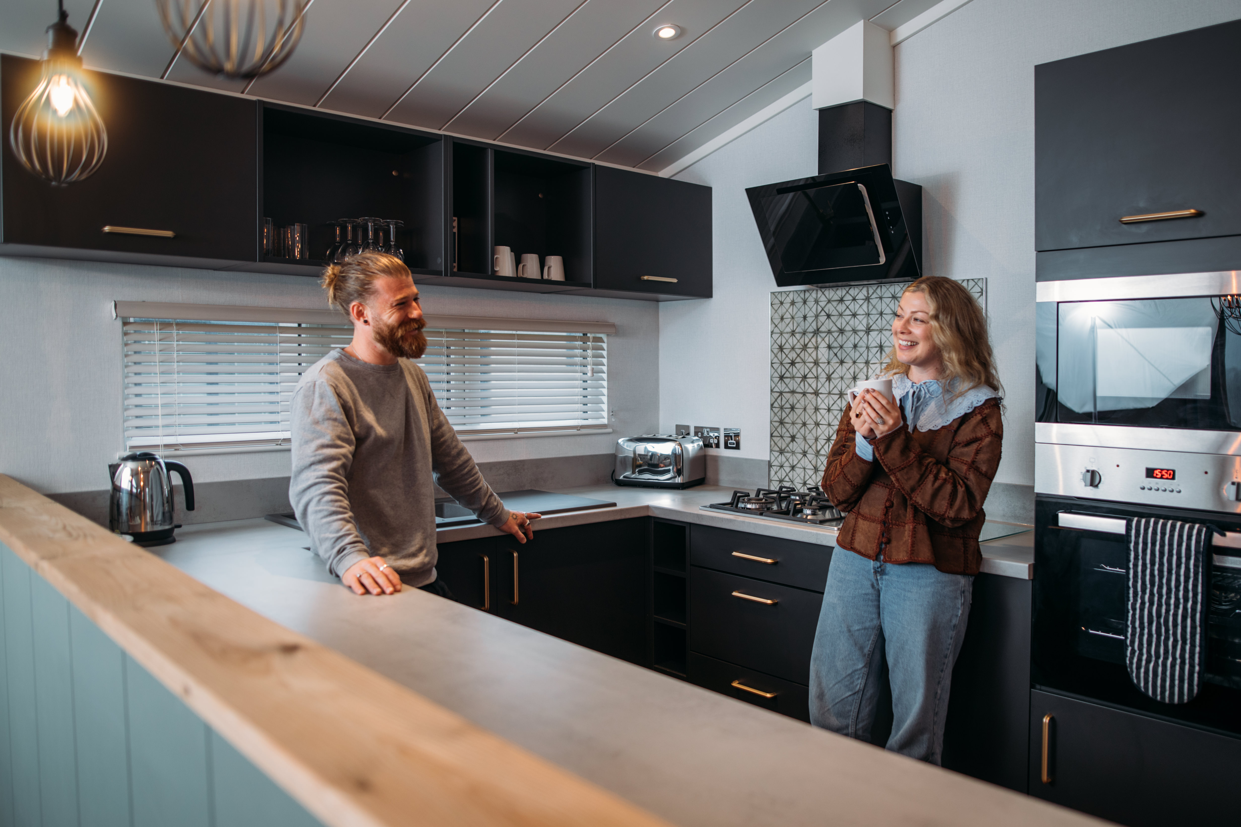 Couple relaxing in kitchen with hot drink