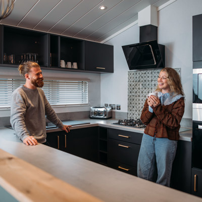 Couple relaxing in kitchen with hot drink