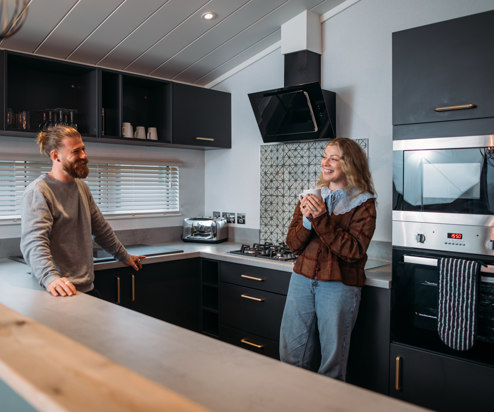 Couple relaxing in kitchen with hot drink