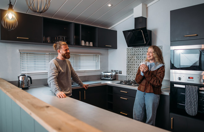 Couple relaxing in kitchen with hot drink
