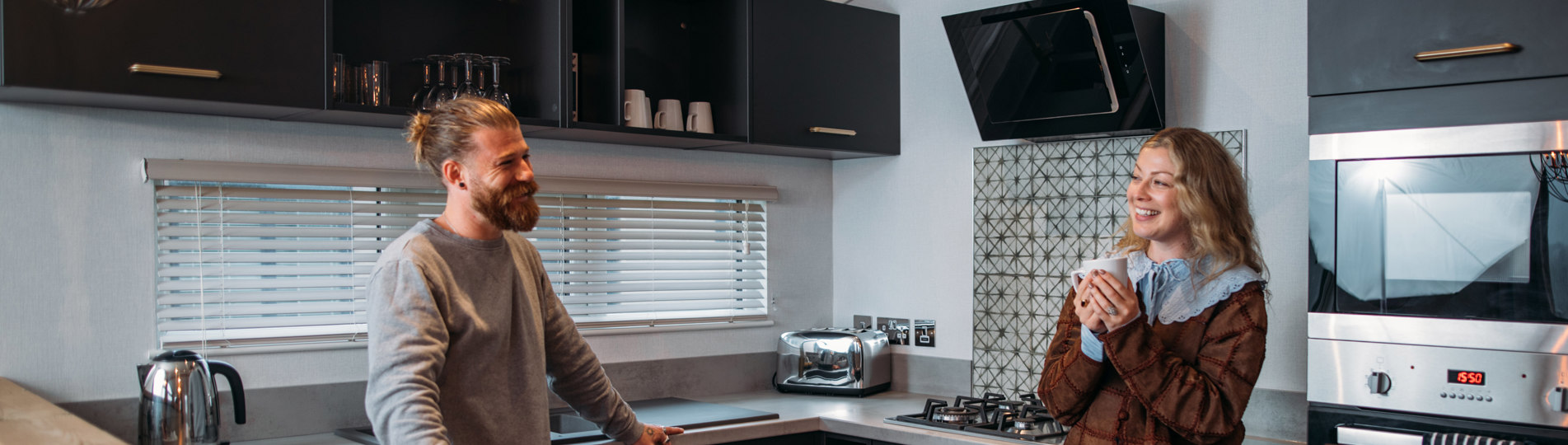 Couple relaxing in kitchen with hot drink
