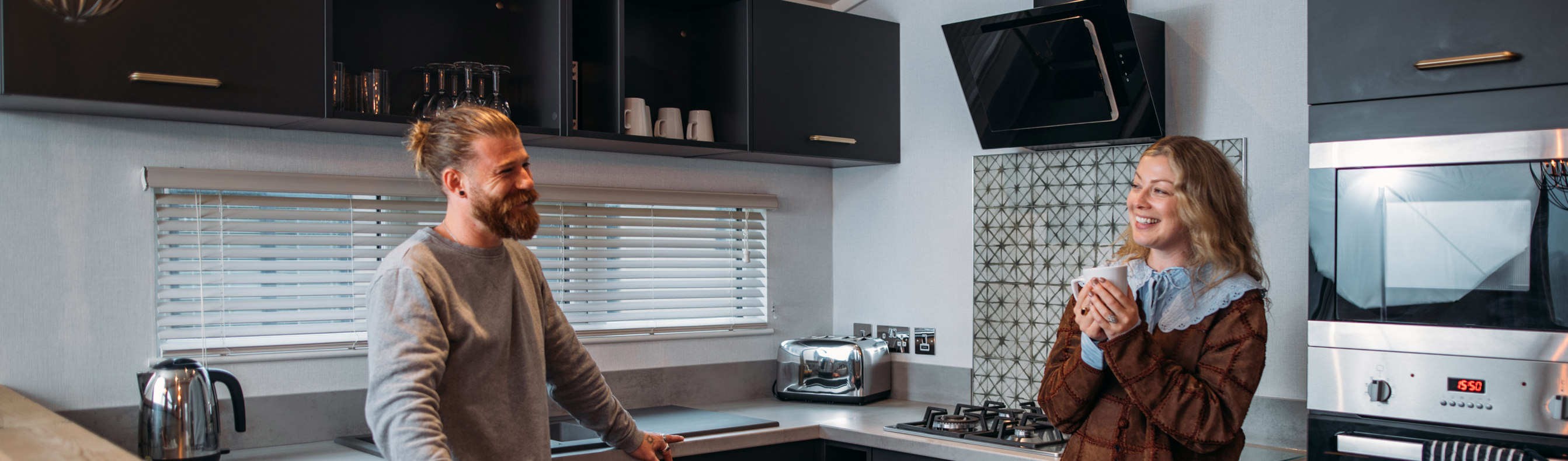 Couple relaxing in kitchen with hot drink