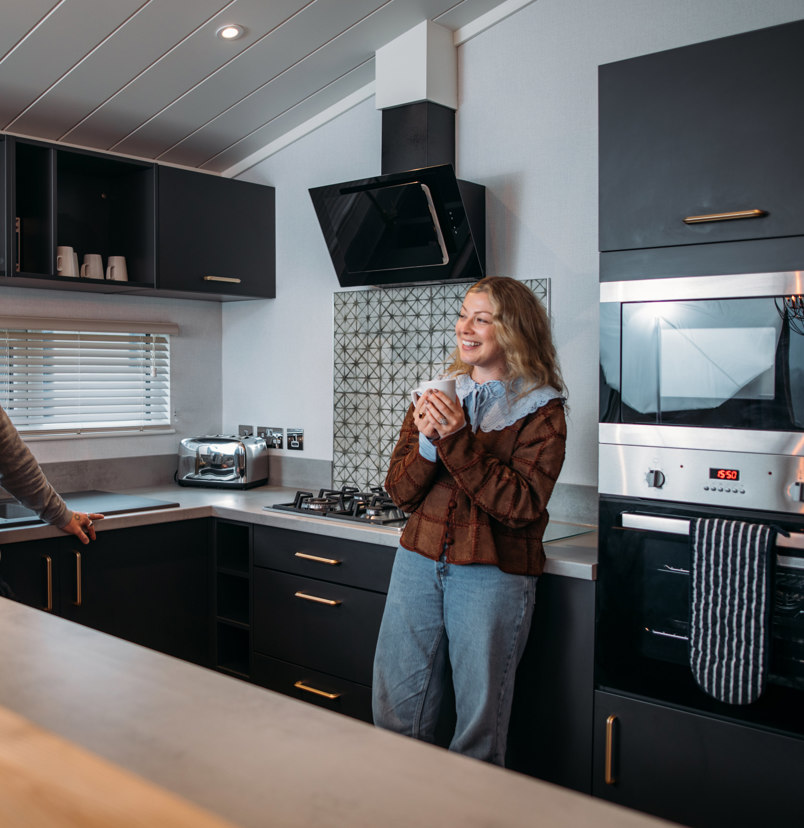 Couple relaxing in kitchen with hot drink