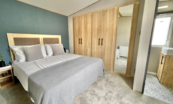 Internal of a caravan master bedroom with storage and ensuite