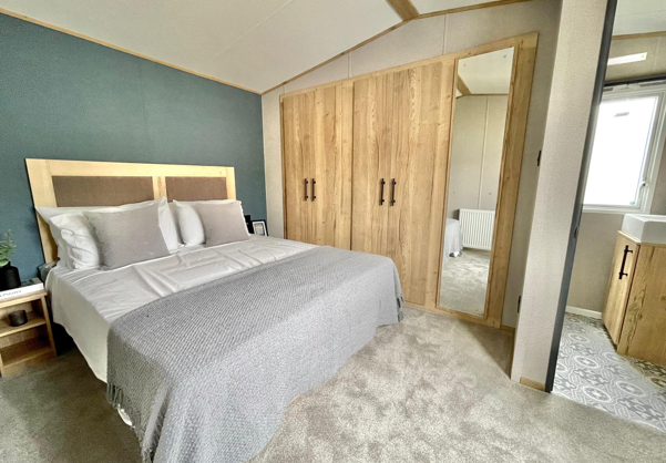 Internal of a caravan master bedroom with storage and ensuite