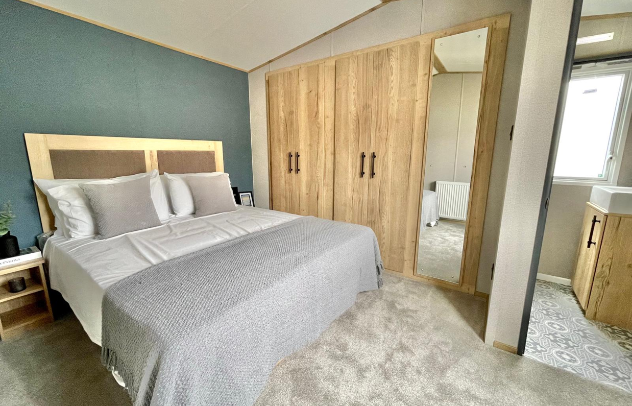 Internal of a caravan master bedroom with storage and ensuite